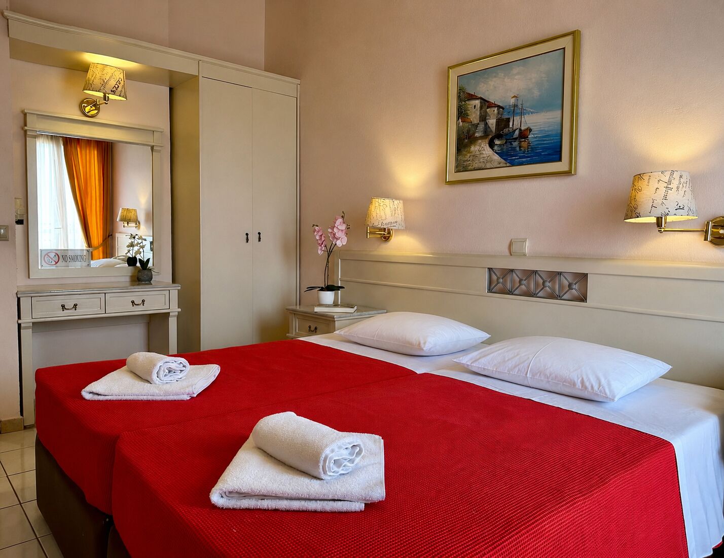 A hotel room with a bed, a nightstand, a dresser, a mirror, and a painting on the wall.