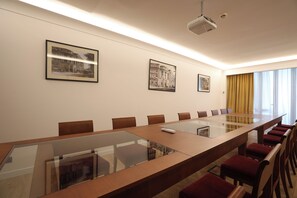 A conference room with a long table, chairs, and framed pictures on the wall. - Grand Hotel Yerevan (Yerevan)
