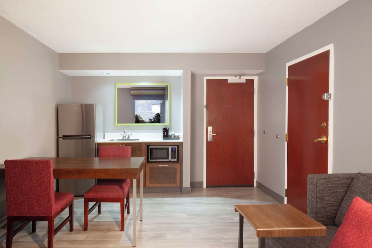 A compact living space with a dining area, kitchenette, and a sofa.