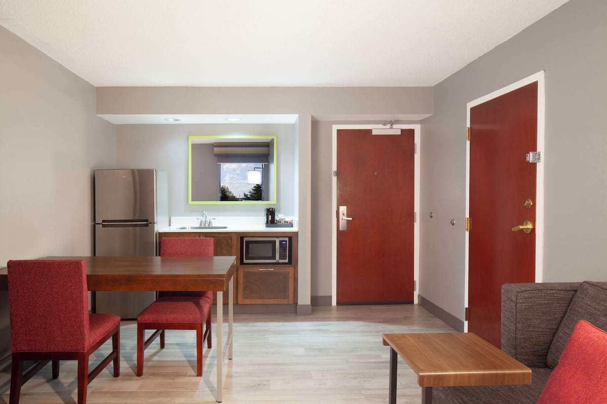 A compact living space with a dining area, kitchenette, and a sofa.