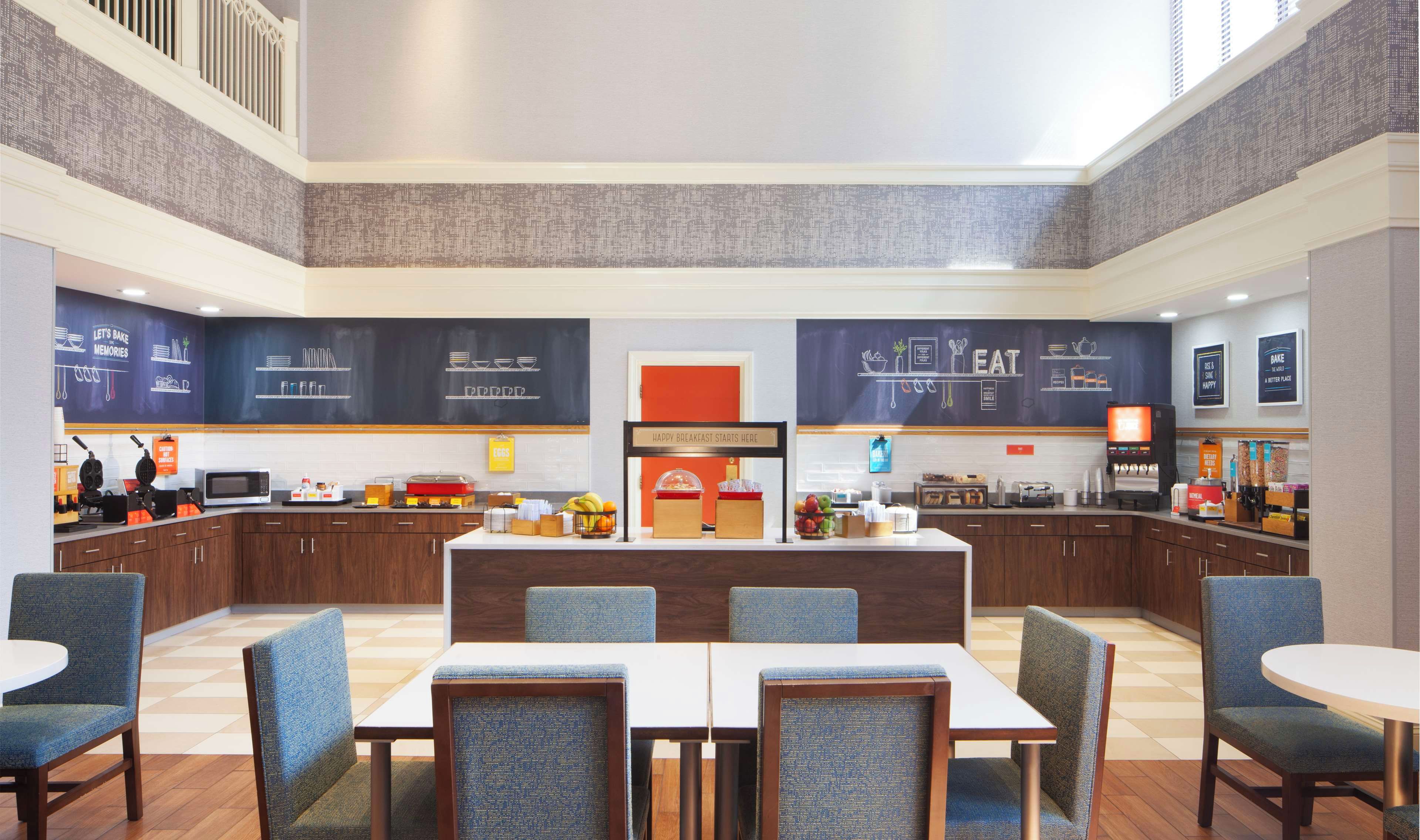 Un moderno espacio para desayunar con una barra central, asientos y electrodomésticos de cocina.