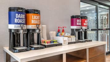 A coffee station with self-service dispensers for dark and light roast coffee, and hot water.