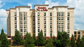 A hotel with a prominent sign reading "Hampton Inn & Suites." It features a modern design with multiple floors and a flat roof. - Hampton Inn & Suites Atlanta Airport North I-85 (Atlanta)
