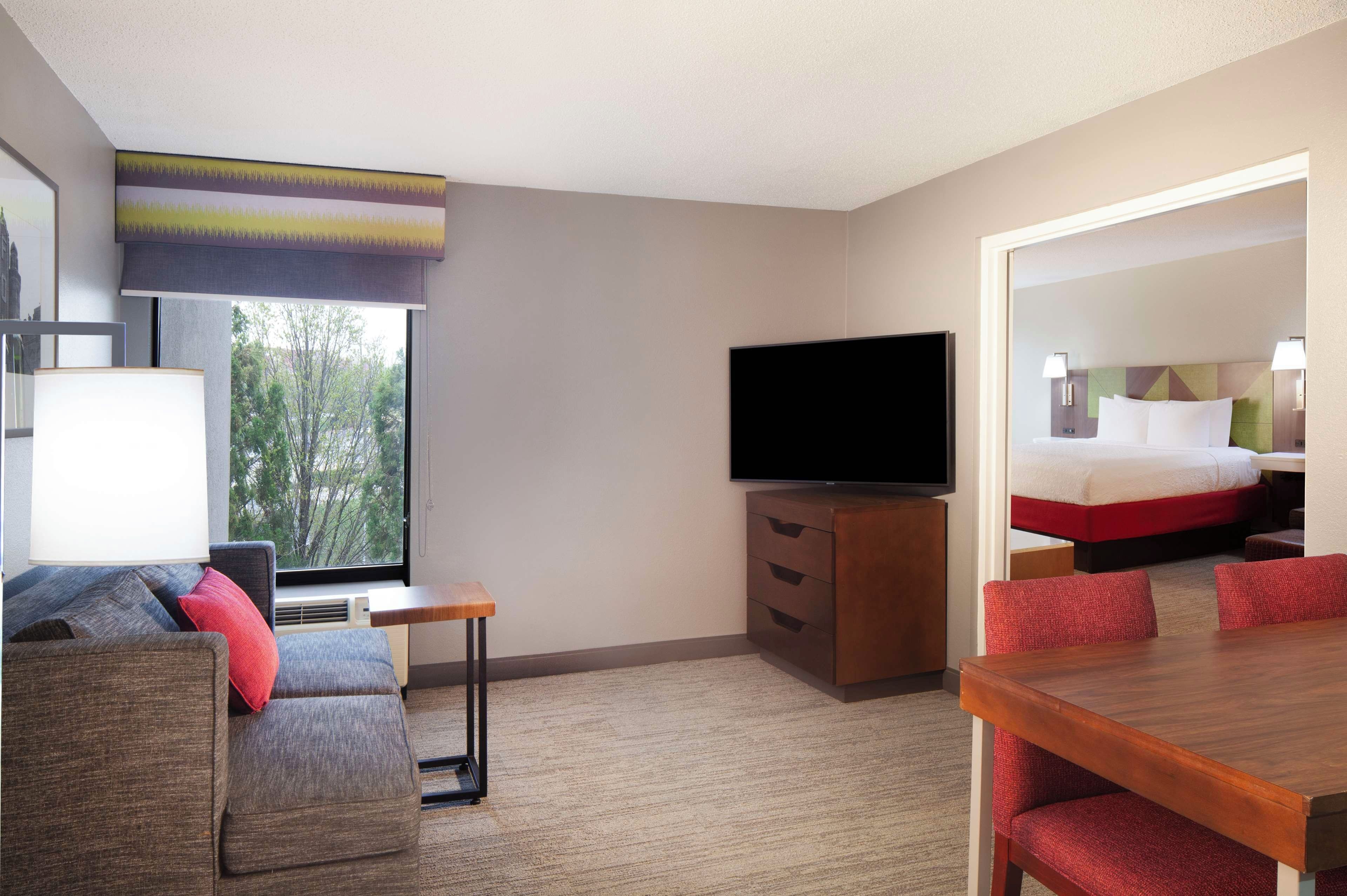 Une chambre d’hôtel avec un lit, une télévision, un bureau, une chaise et un canapé.