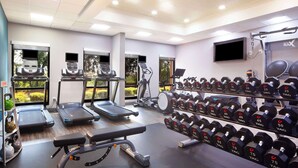 A gym with treadmills, ellipticals, a bench press, and a rack of dumbbells. - Hampton Inn & Suites Atlanta Airport North I-85 (Atlanta)