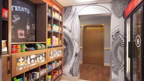 A snack display with various packaged foods and a chalkboard sign. - Hampton Inn & Suites Atlanta Airport North I-85 (Atlanta)