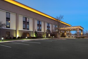 Un hotel moderno con techo plano, amplias ventanas y una entrada acogedora.
