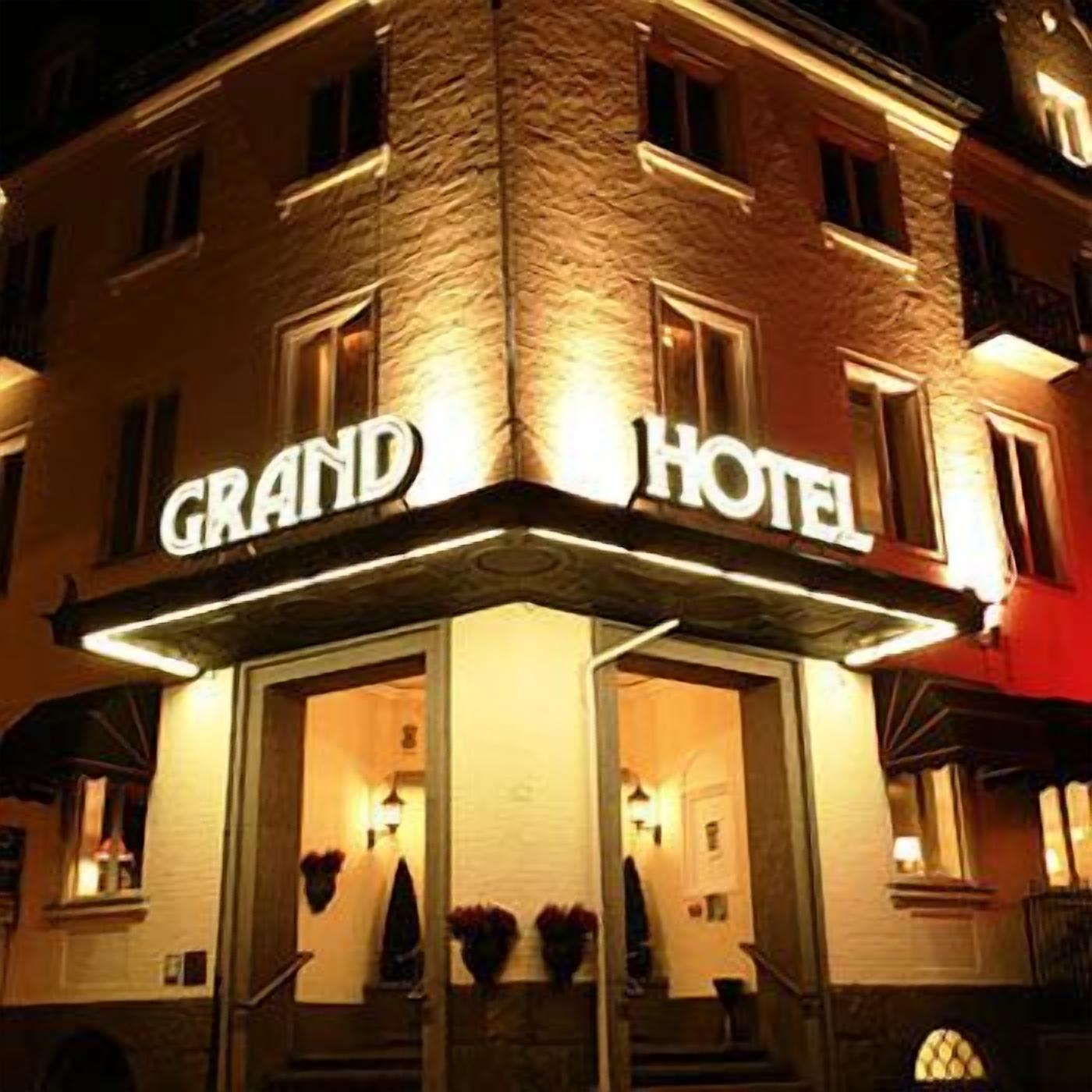 A corner building with a sign reading "GRAND HOTEL".