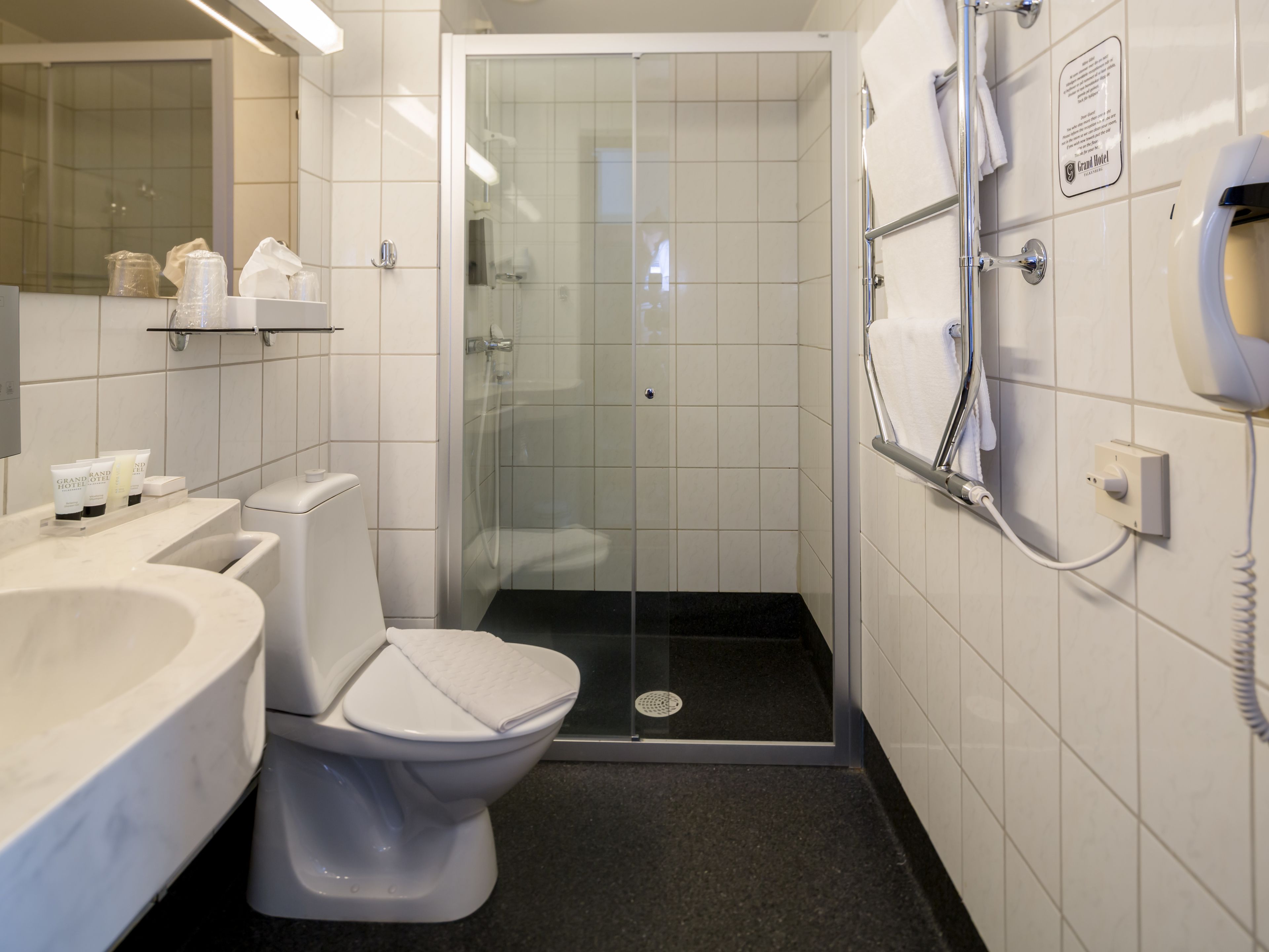 A modern bathroom with a toilet, bidet, and glass-enclosed shower stall.