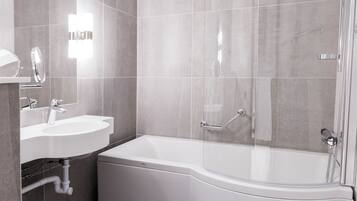 A modern bathroom with a white sink, mirror, and bathtub.