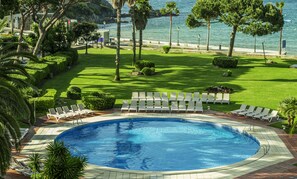 Zona de piscina con sillones y vista al mar.