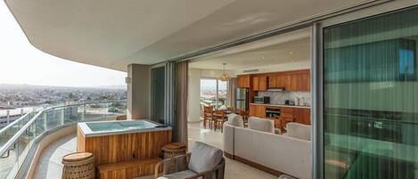 Ein Balkon mit Whirlpool, Sitzgelegenheit und Blick auf die Stadt.