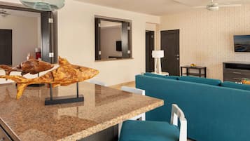 Un salon moderne avec un canapé bleu, une table à manger en granit et une grande sculpture de poisson.