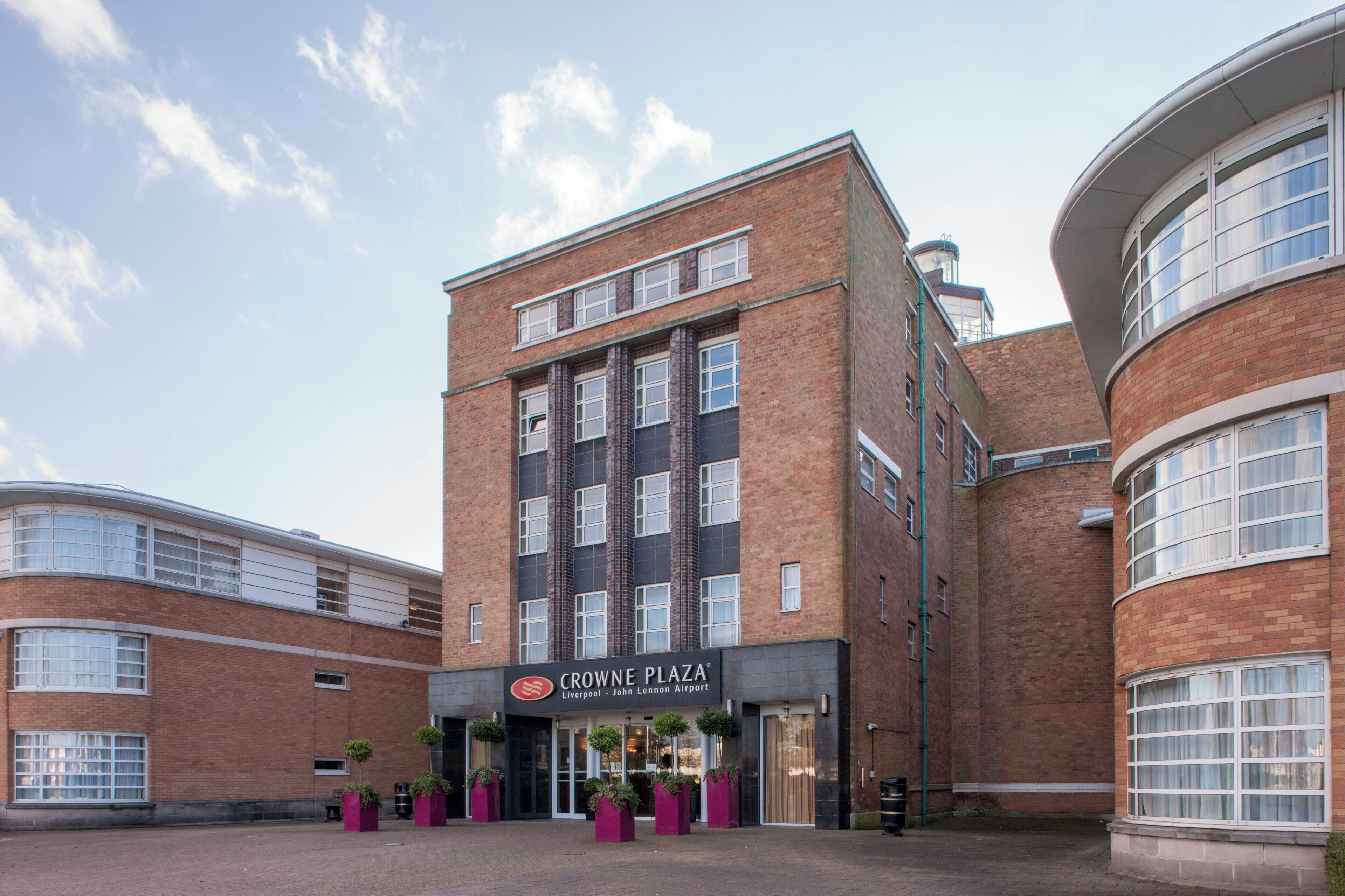 En flervåningsbyggnad med en framträdande skylt för Crowne Plaza, belägen vid Liverpool John Lennon Airport.