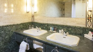 A bathroom with two sinks, a towel rack, and a mirror.