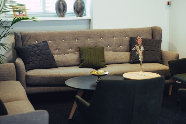 A modern living room with a sofa, a round coffee table, and a chair.