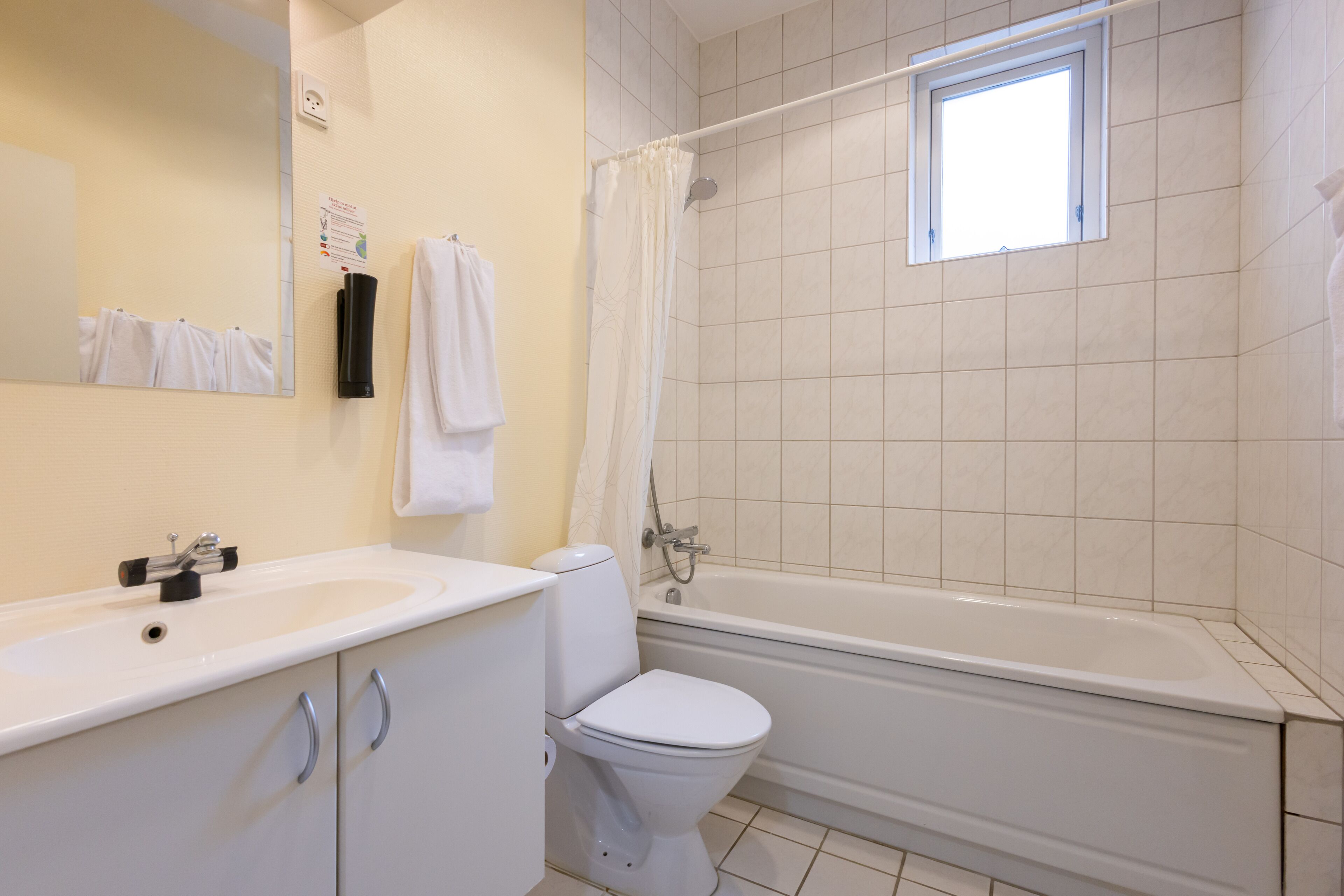 A bathroom with a sink, toilet, and bathtub.