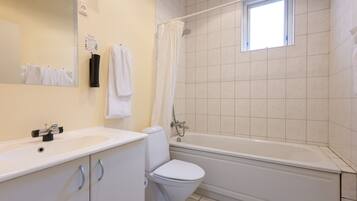 A bathroom with a sink, toilet, and bathtub.