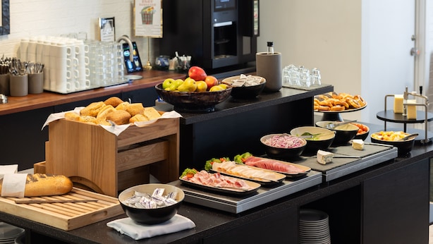 A buffet with various food items, including fruits, cheeses, meats, and bread. - Milling Hotel Gestus (Aalborg)