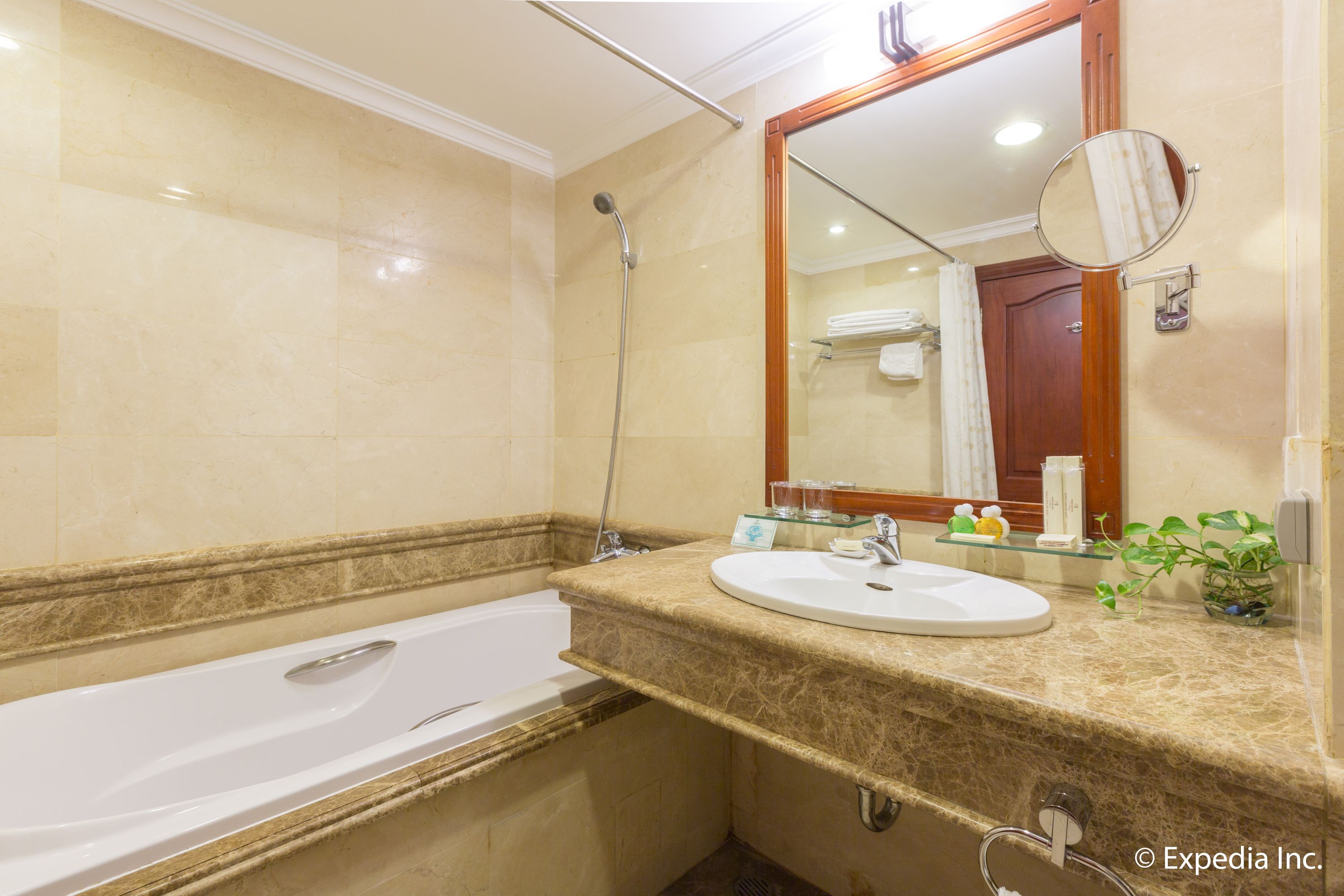 Une salle de bain avec une baignoire, un lavabo, un miroir et une douche.