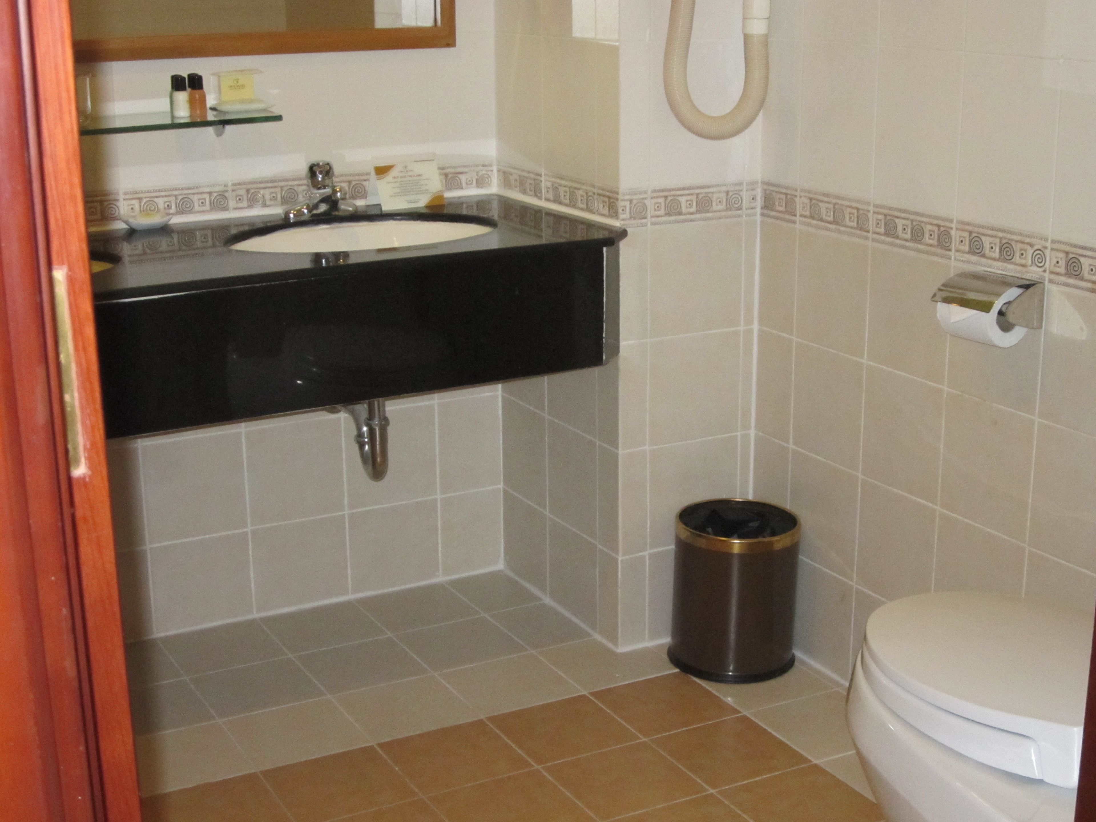 Un baño con lavabo, inodoro y cubo de basura.
