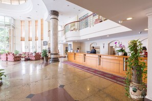 Welcome to our hotel lobby, featuring a spacious area with a reception desk, seating areas, and a mezzanine level.