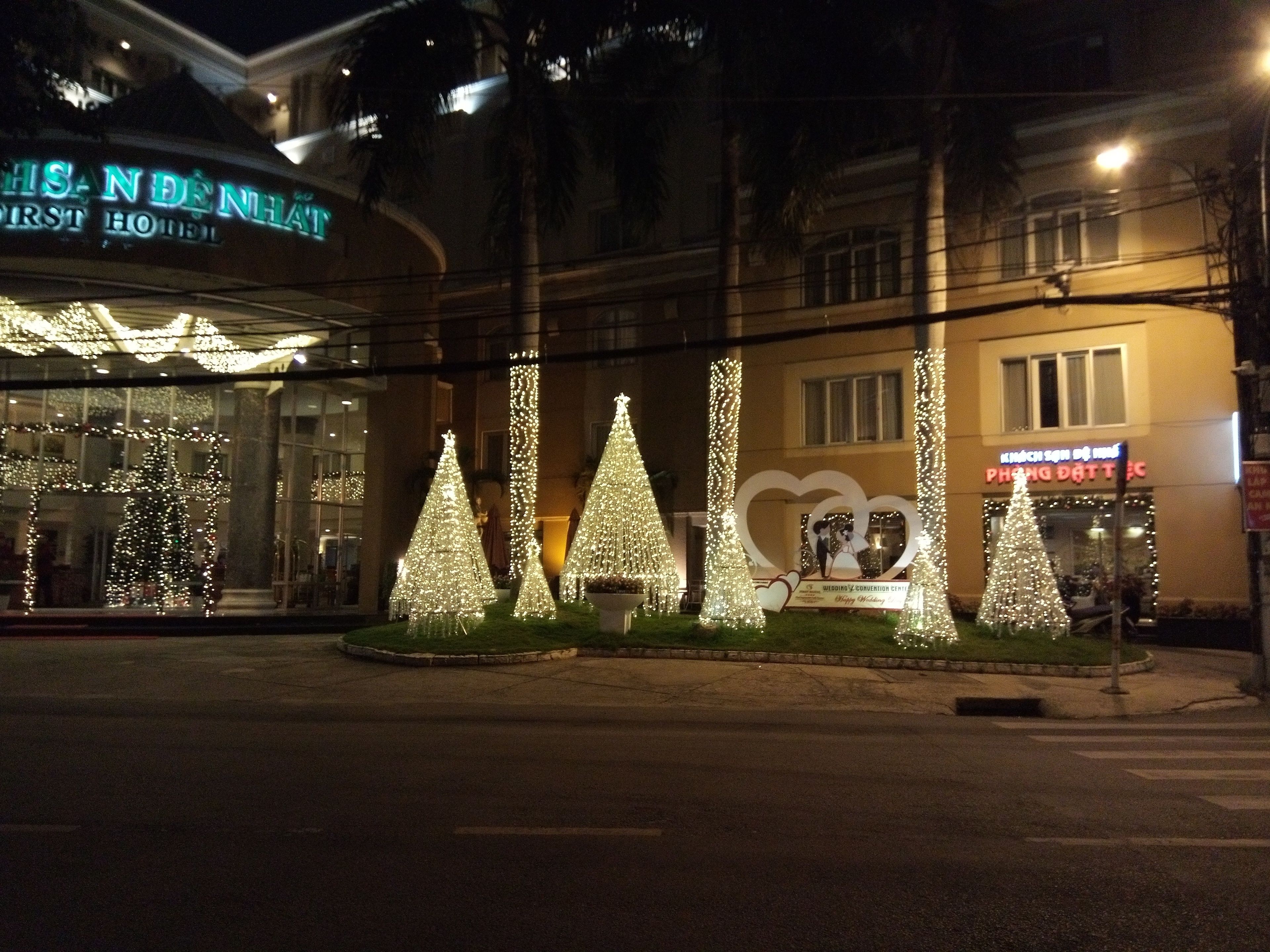 A hotel with a Christmas tree display in front.