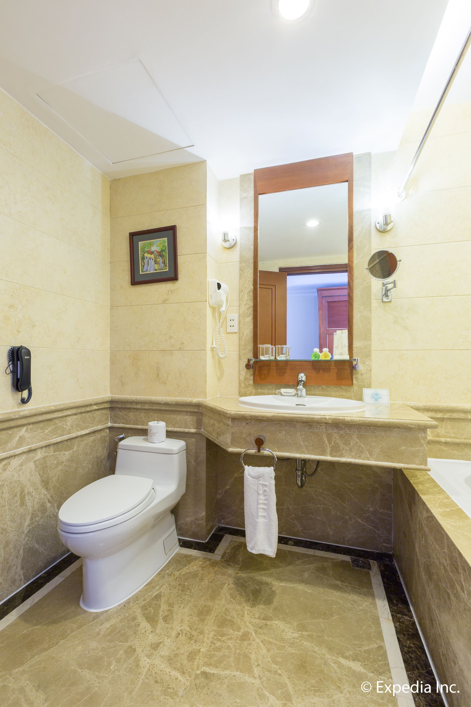 Une salle de bain avec des toilettes, un lavabo et un miroir.