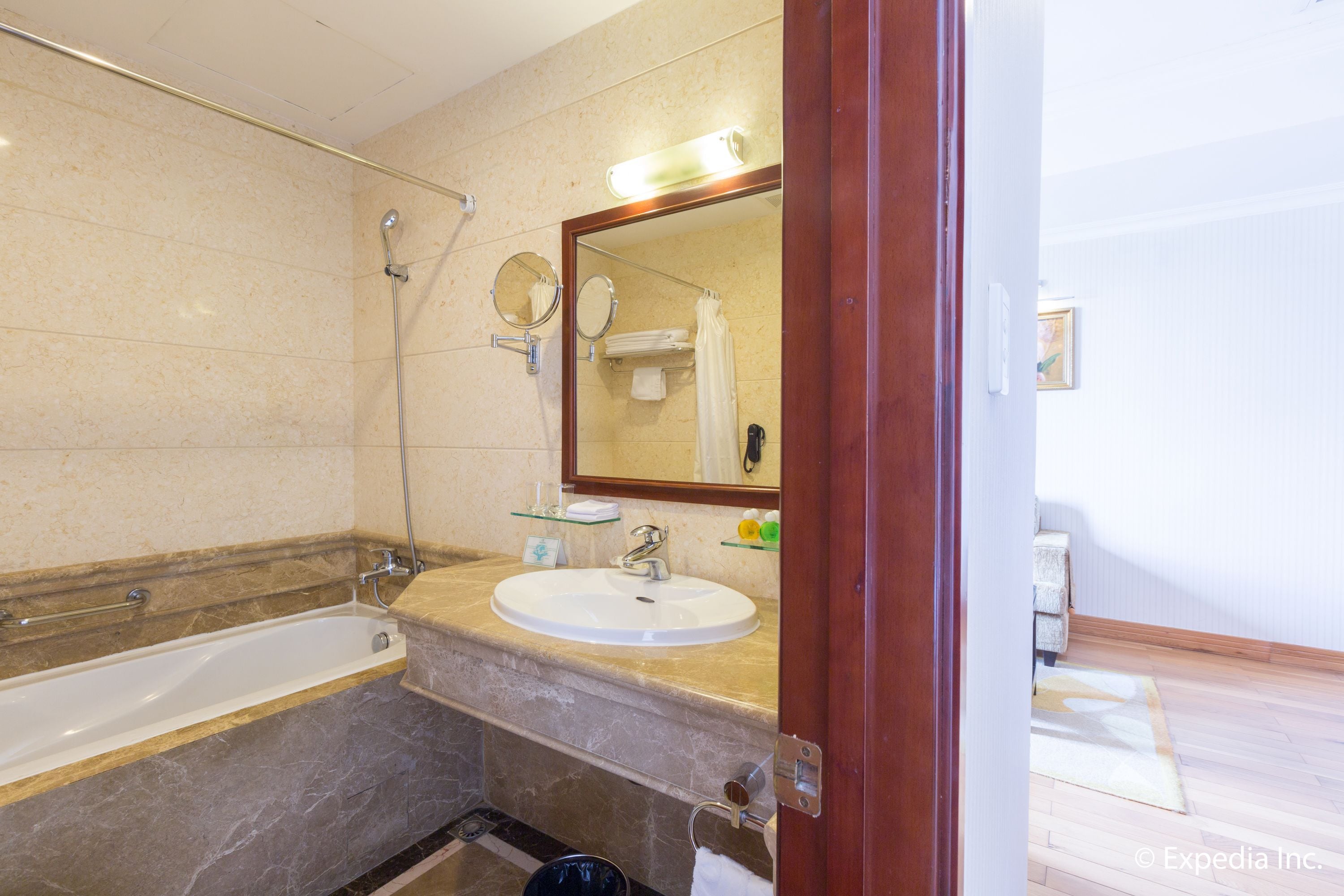 A bathroom with a bathtub, a sink, a mirror, and a shower.