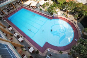 Relax by the pool surrounded by lounge chairs and umbrellas.