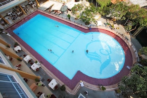 Relax by the pool surrounded by lounge chairs and umbrellas.