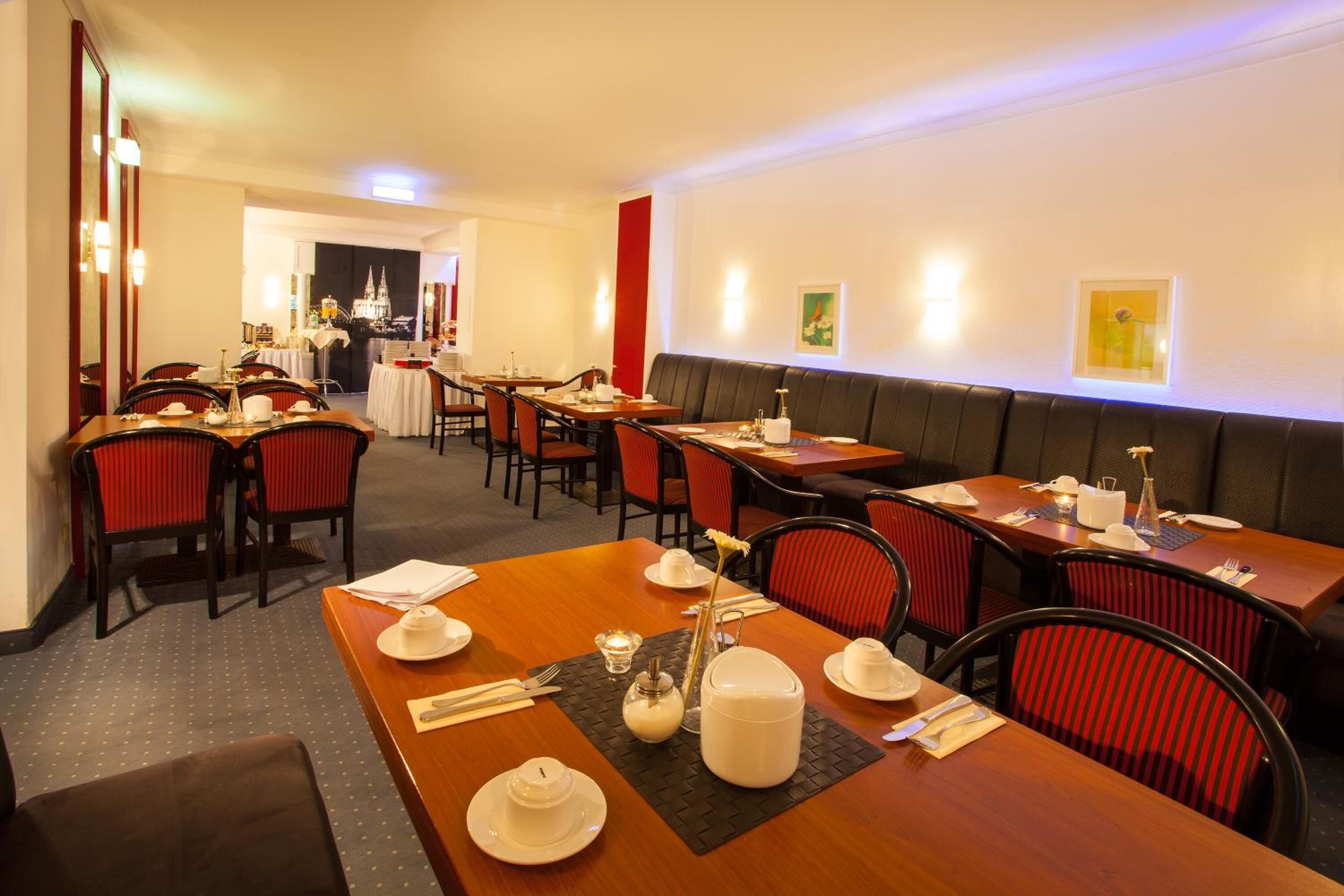 Un restaurant doté de nombreuses tables, de chaises et d’un espace de repos central.