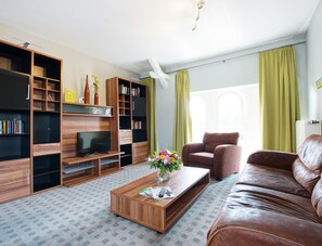 Relax in this stylish living room with a flat-screen TV, leather sofa, and coffee table.