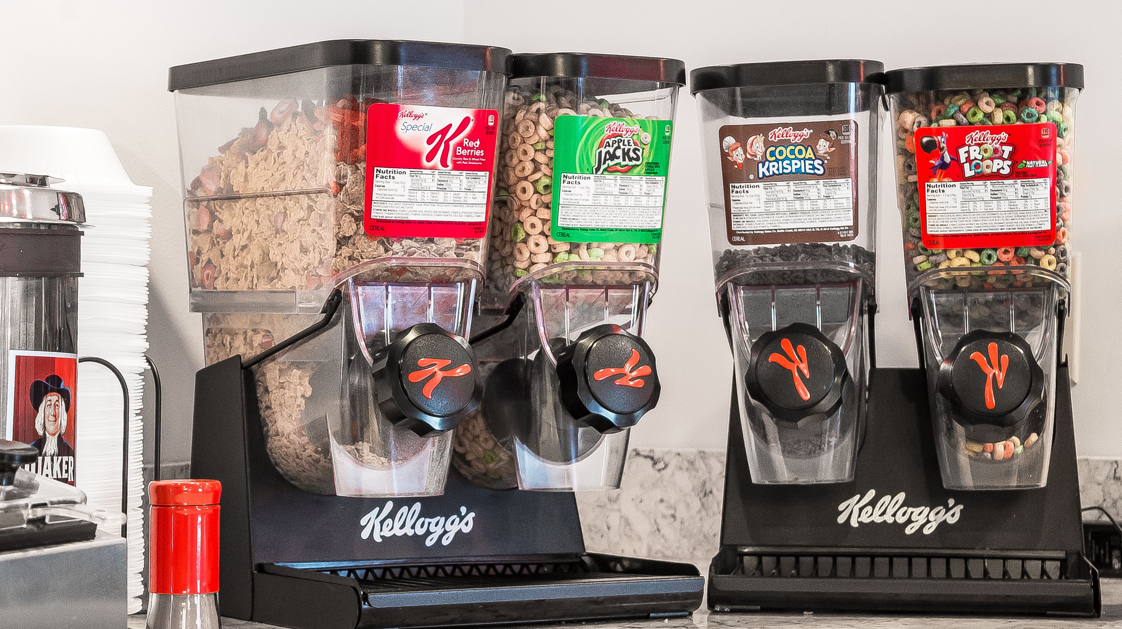 Quatre distributeurs de céréales Kellogg's proposant différentes saveurs.