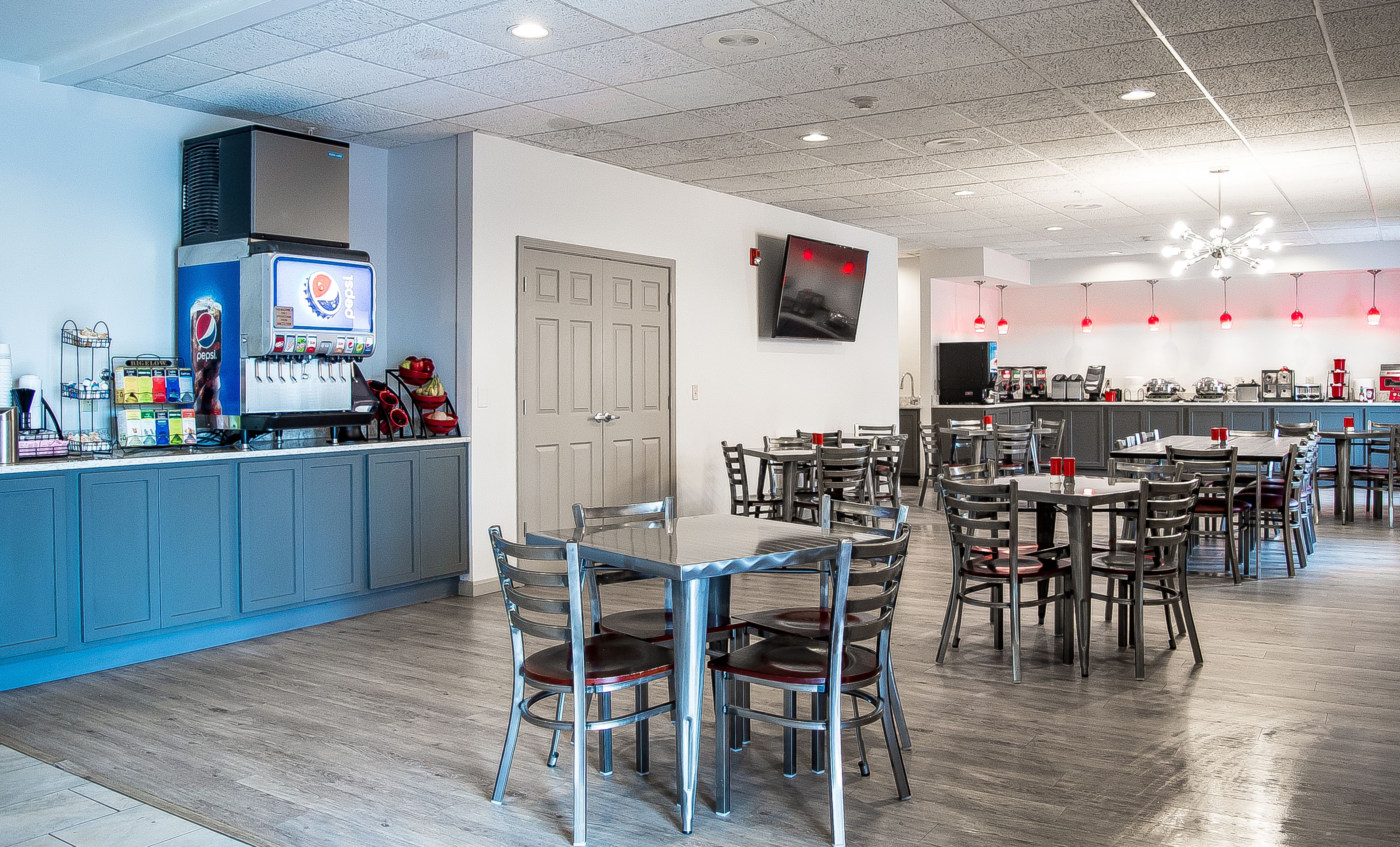 A restaurant with a bar area, tables, and chairs.