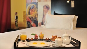 A breakfast tray with eggs, juice, and pastries on a hotel bed. - Mercure Alger Aeroport (Algiers)