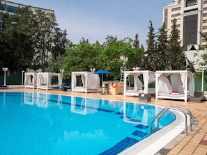 Une piscine dotée de chaises longues et de parasols.