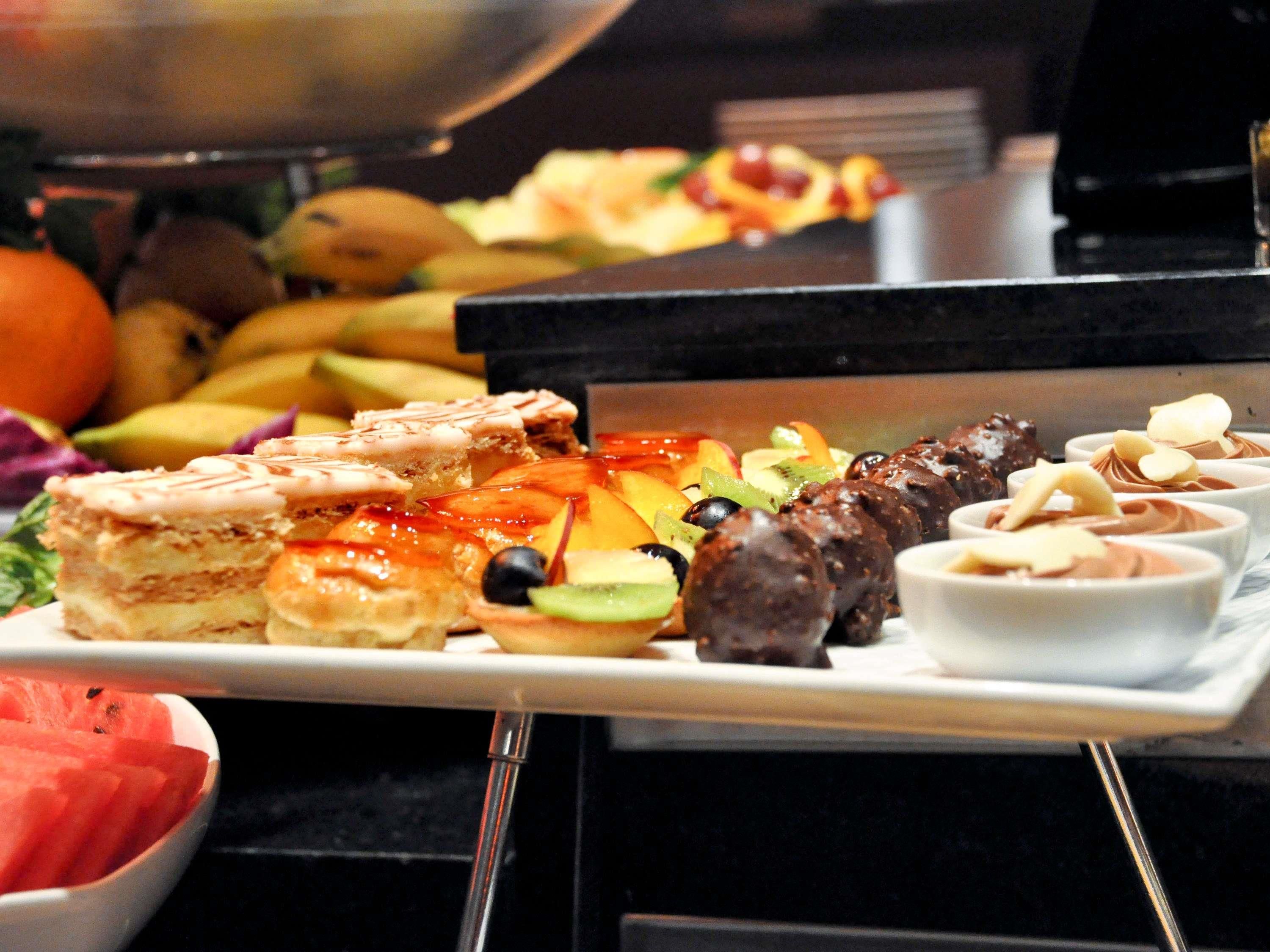 A buffet with various food items including fruits, vegetables, and desserts.