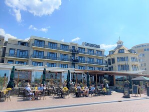 Un hôtel doté d’une terrasse, de plusieurs balcons et offrant une vue sur un ciel dégagé.