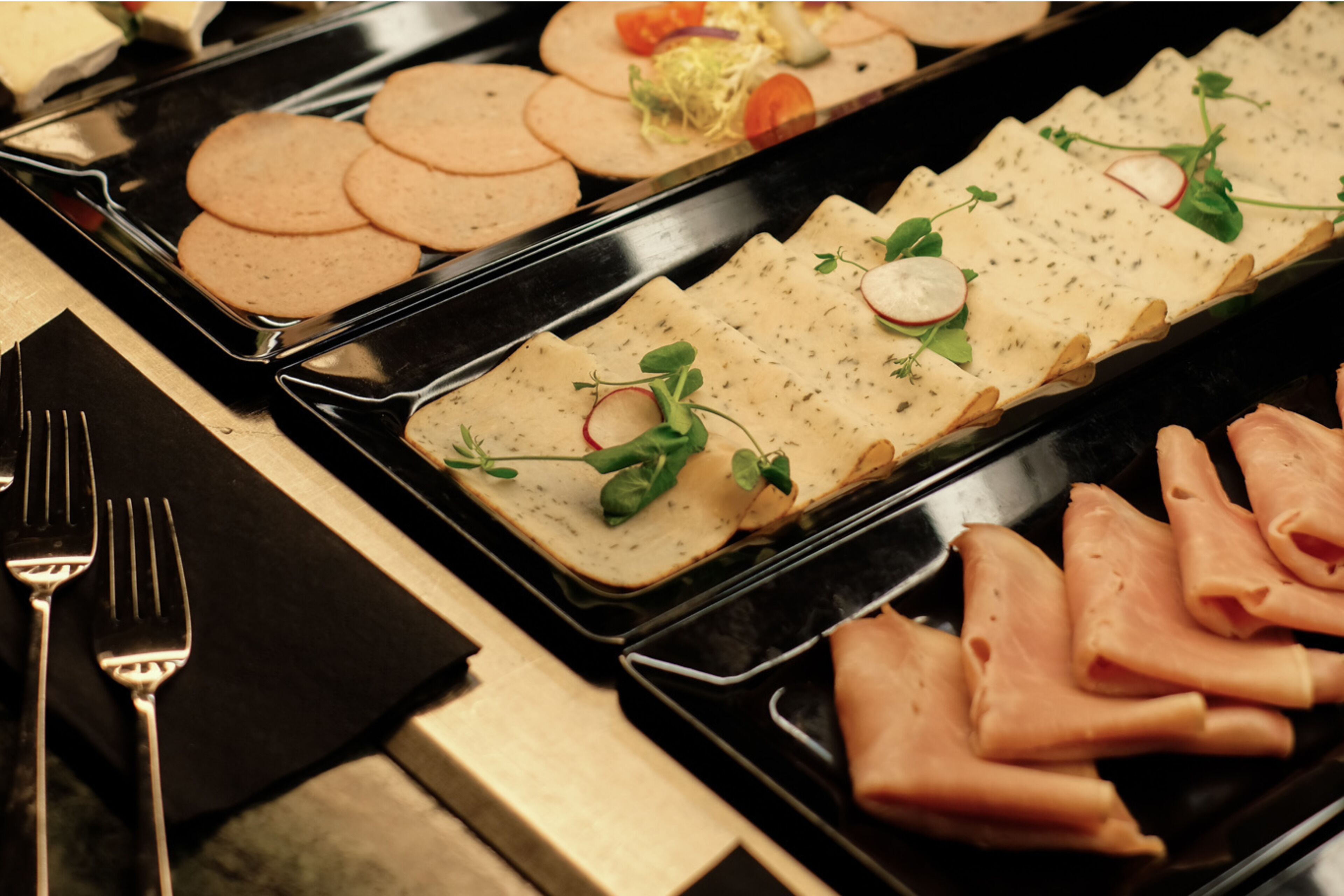 A buffet with various food items including tortillas, meat, and garnishes.