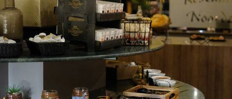 A bar area with a coffee machine, jars of condiments, and a sign reading "Restaurant Nood."