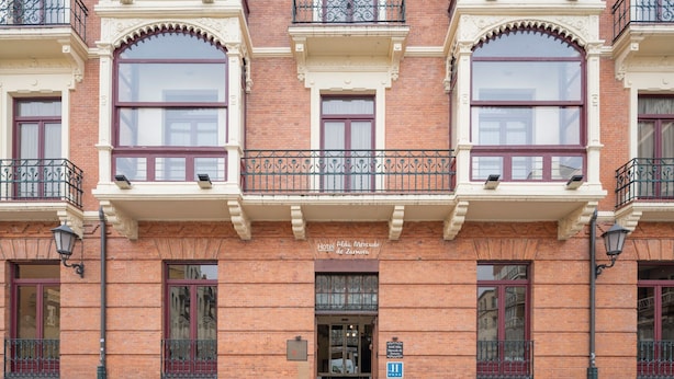 A multi-story building with a classic architectural style, featuring arched windows and decorative balconies.