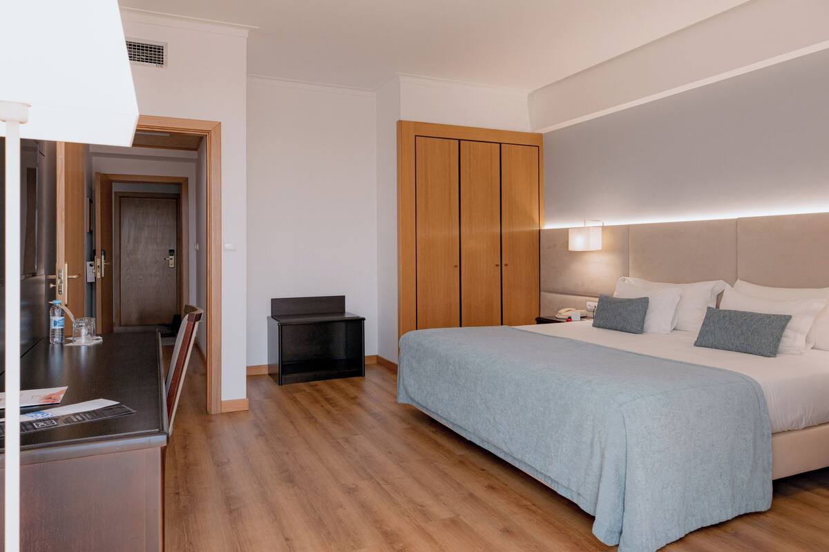Un dormitorio con cama, mesita de noche y armario.