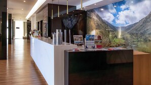 A reception desk with a scenic mural of a mountainous landscape.
