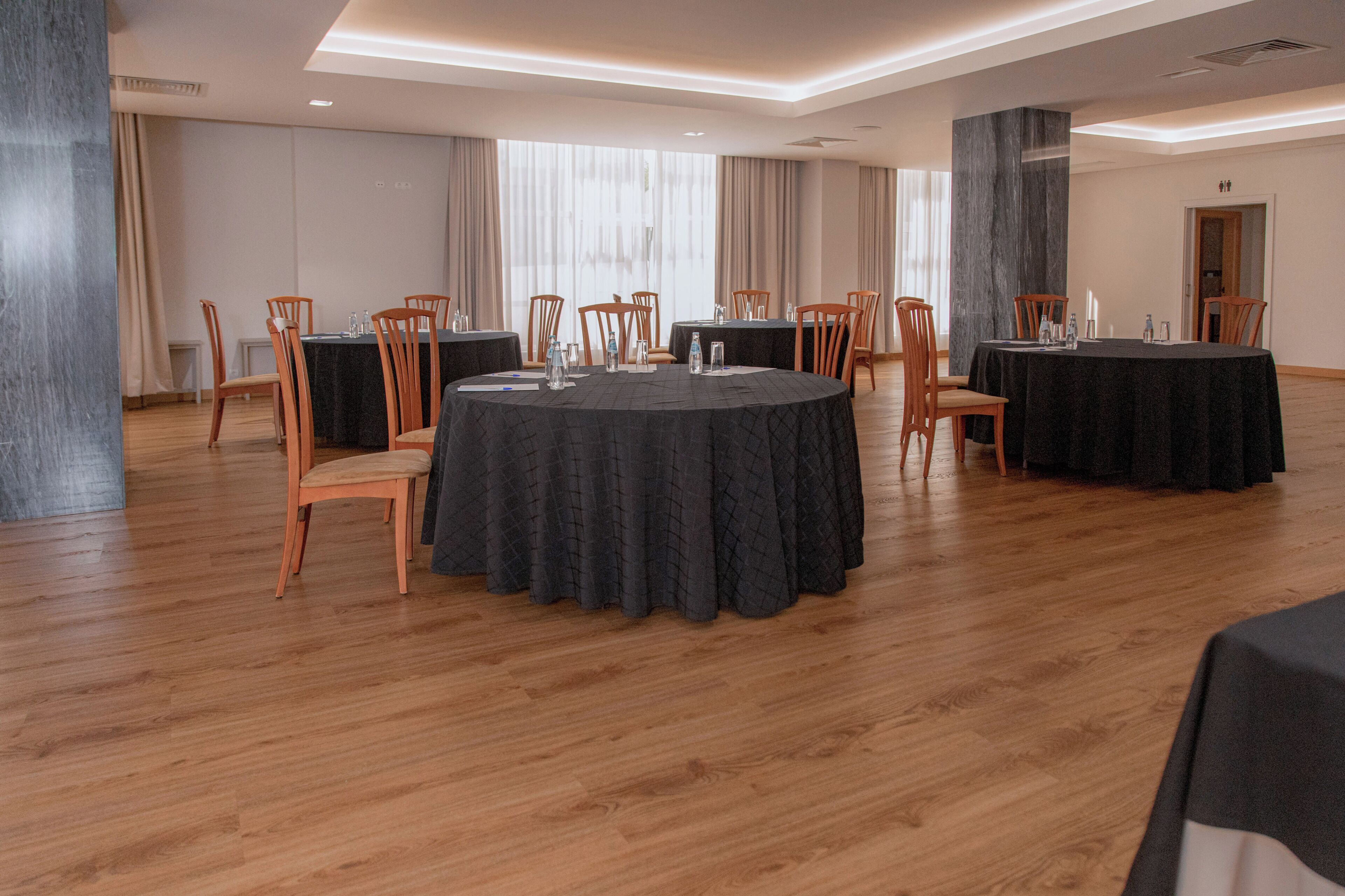 A conference room with round tables, chairs, and a modern interior design.