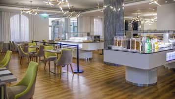 Un restaurant moderne doté d’un bar central, de plusieurs espaces de restauration et d’un éclairage contemporain.