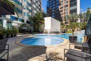 Una piscina cubierta, una piscina al aire libre, tumbonas