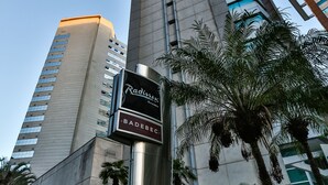 A tall building with a sign for Radisson and a street number 420. - Radisson Hotel Vila Olimpia (São Paulo)