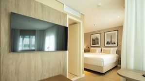 A hotel room with a bed, a bench, a TV mounted on the wall, and two framed pictures on the wall. - Radisson Hotel Vila Olimpia (São Paulo)