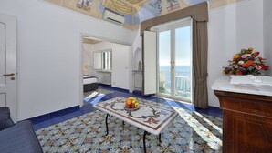Una habitación con suelo de baldosas, una mesa con fruta, un armario de madera y vistas por una puerta.